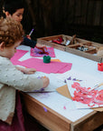 Kids sitting and crafting at a hardwood multipurpose table