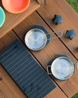 Detail vertical image of a play hot plate, grille and knobs on a timber mud kitchen on grass with two pots