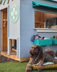 Close up of a vet themed grey and green cubby house front corner staged with soft toys and cut dog posing out the front