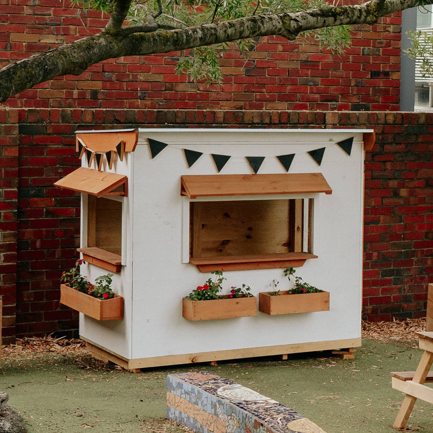 A school yard with painted white wooden commercial grade cubby house