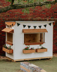 A school yard with painted white wooden commercial grade cubby house