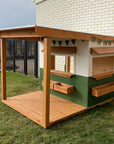 A white and green wooden cubby house with front verandah education commercial grade