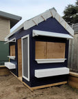 A commercial grade pitched roof cubby house painted navy blue with white trims