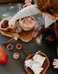 Close-up of Exploration & Loose Parts Table in an ELC, with children using coloured sand and sensory play materials on the chalkboard top.