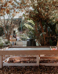 Thermory timber Exploration & Loose Parts Table in an outdoor ELC setting with natural play materials in dividers.