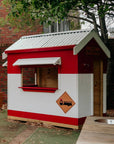A painted fire station wooden cubby house in a school playground