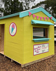 A painted wooden cubby house themed as an ice cream shop as part of an education village play space
