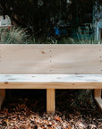 A pine timber bench seat with sloped back in an early learning centre yard