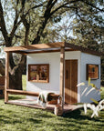 Front and side view of Signature Modern cubby house in backyard under tree canopy