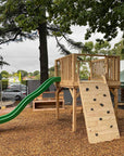 A beautiful timber platform in a nature play space with climbing wall and slide