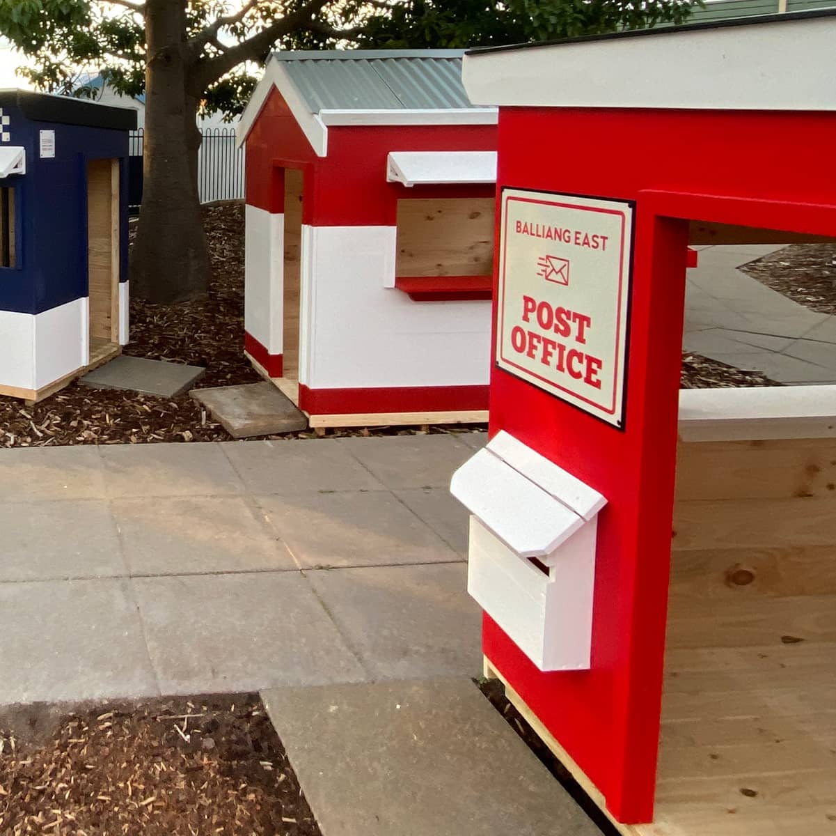 A cubby house village scene with post office and mailbox