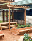 Raised timber garden bed with seating in landscaped outdoor classroom