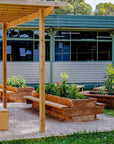 Raised timber garden bed with seating in landscaped outdoor classroom and vegetable garden