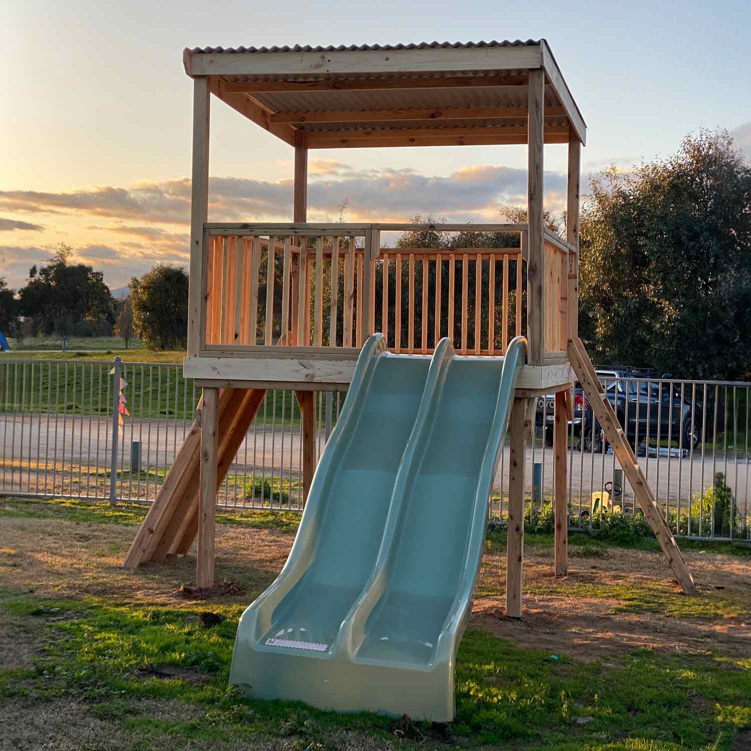 Raised platform cubby house with ladder and slides