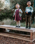 kids standing on a wooden bench