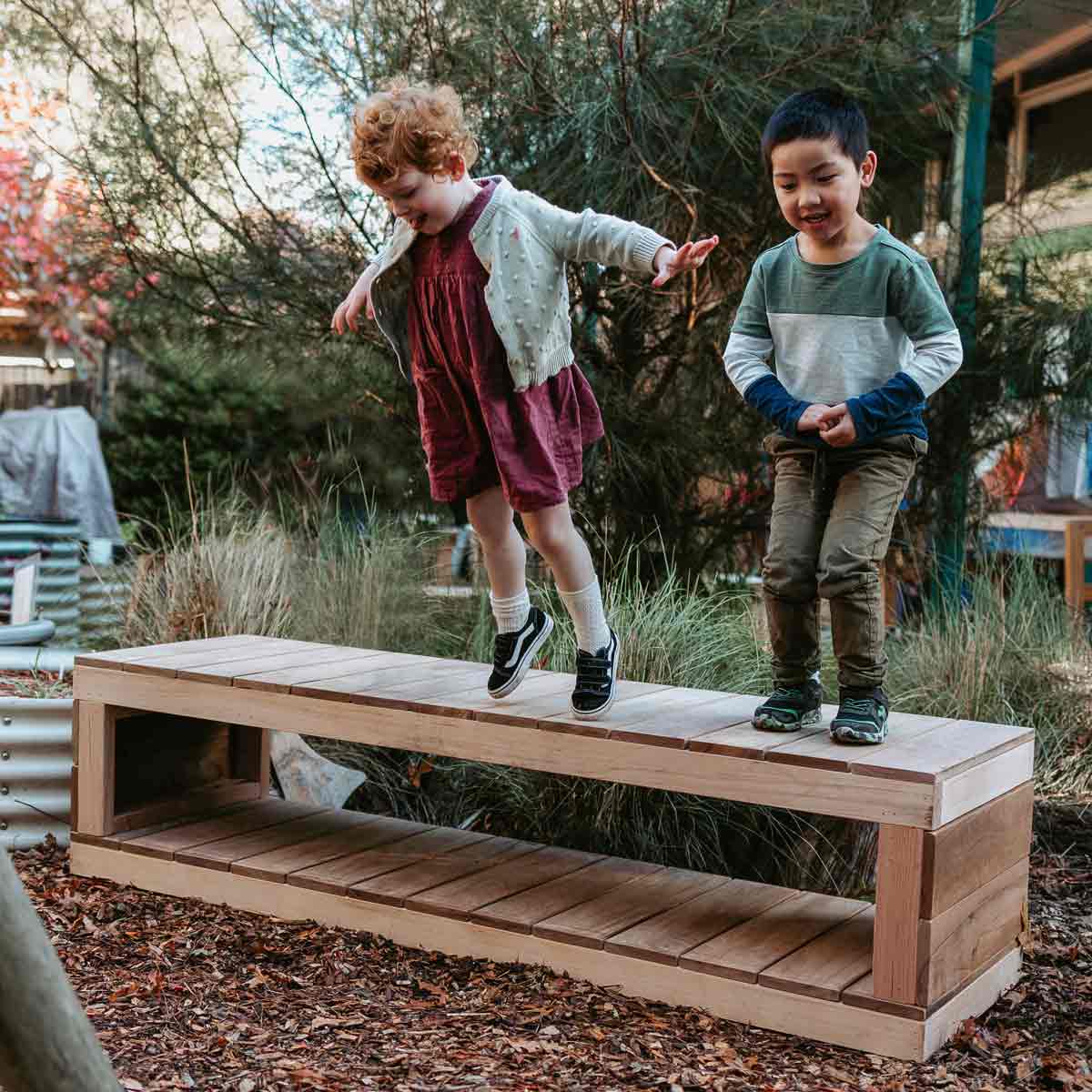 kids standing on a wooden bench