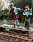 kids standing on a wooden bench