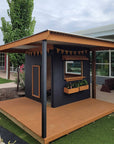 A painted wooden cubby house with a wraparound verandah and deck in an education setting