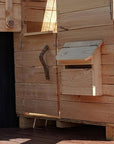 A wooden toy letterbox on an outdoor cubby house