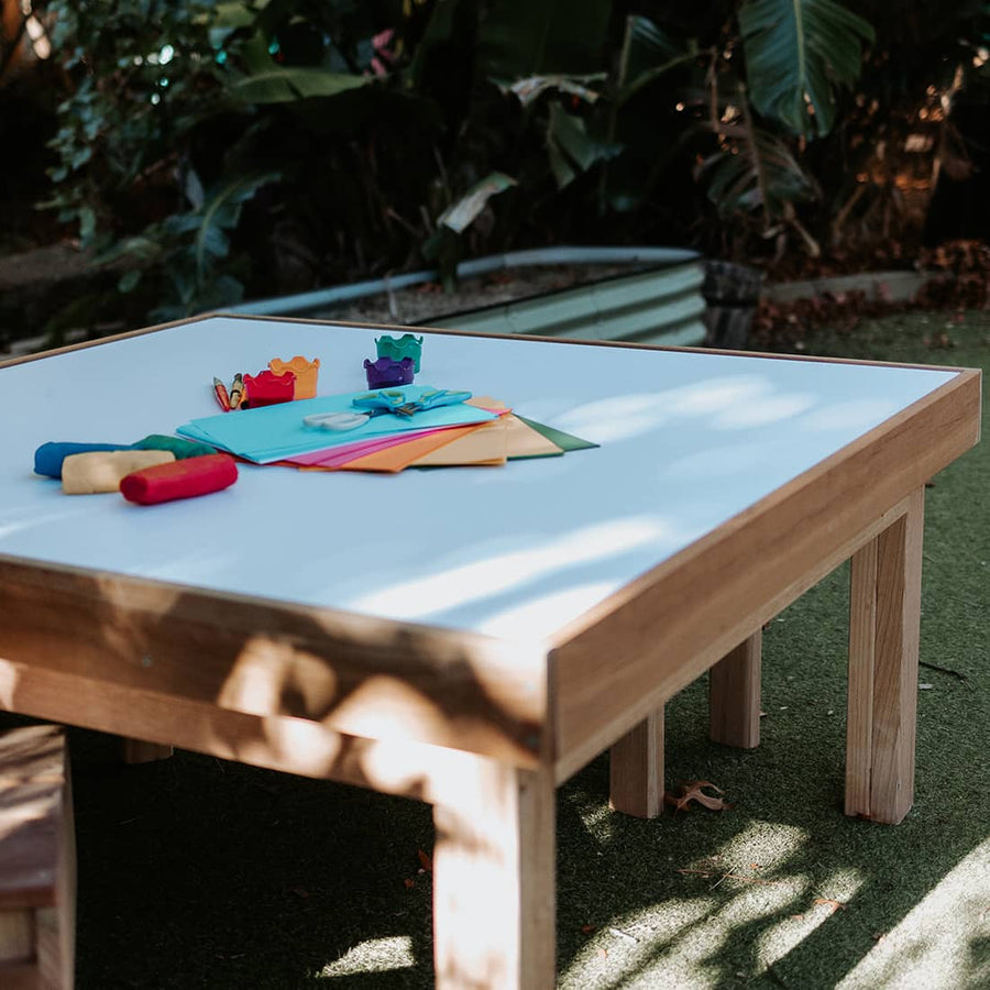 A timber arts and crafts table in an early learning centre yard