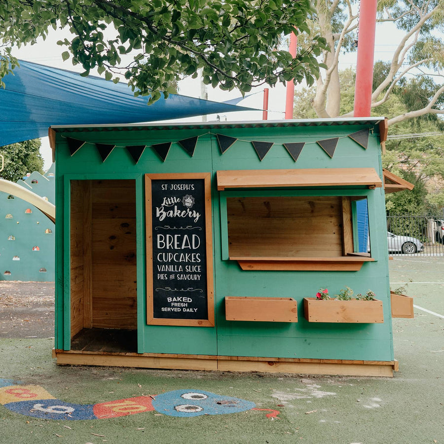 A painted bakery themed wooden cubby house in an education play space