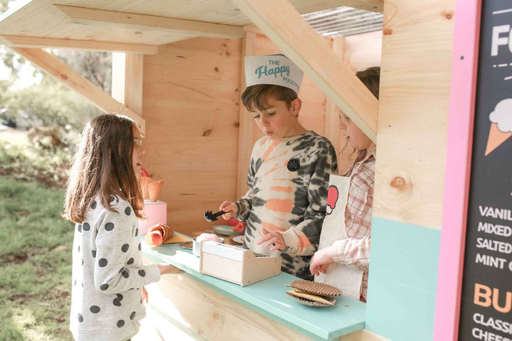 Kids playing in a Wooden Cubby House themed as am Ice Cream Food Truck
