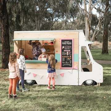 Kids line up at a food truck themed cubby painted white aqua and pink