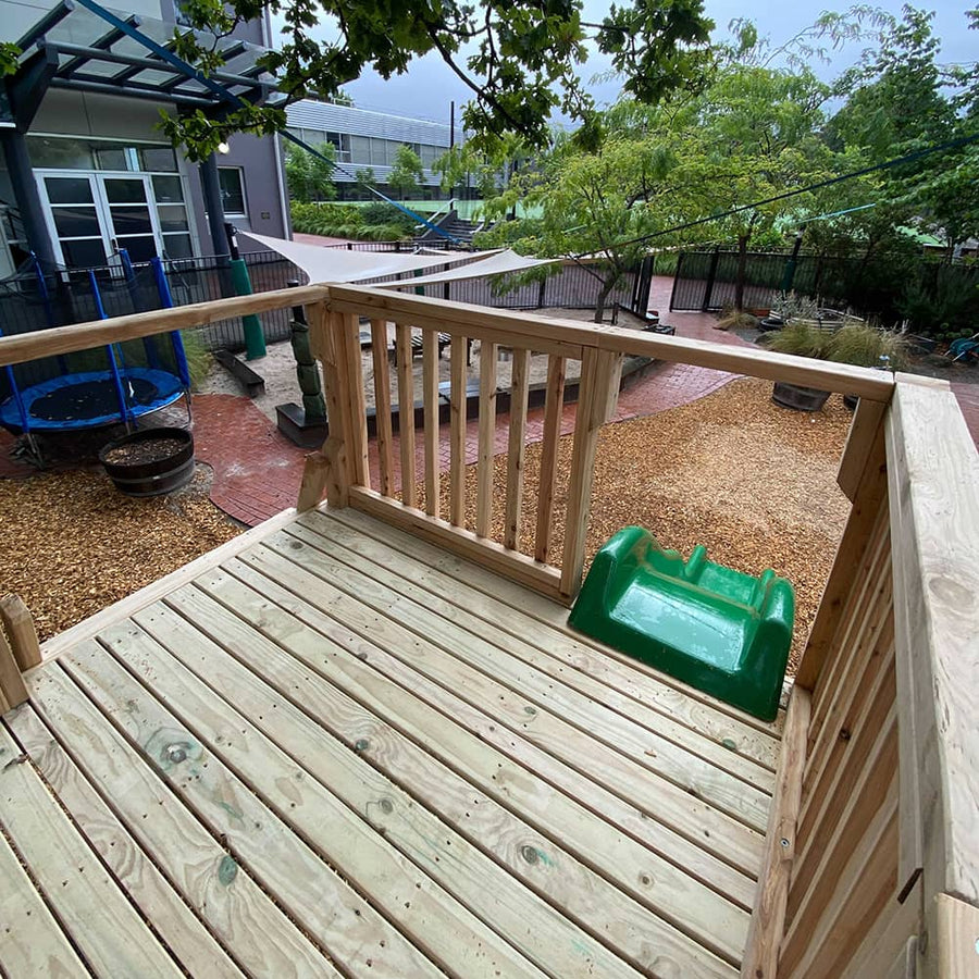The view from the top of a raised wooden platform with ladder and slide