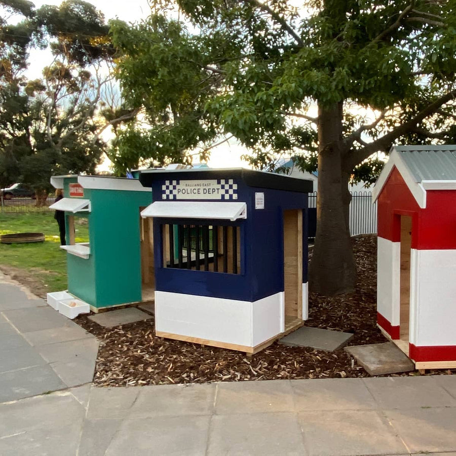 A navy and white painted wooden cubby house styled as a police station