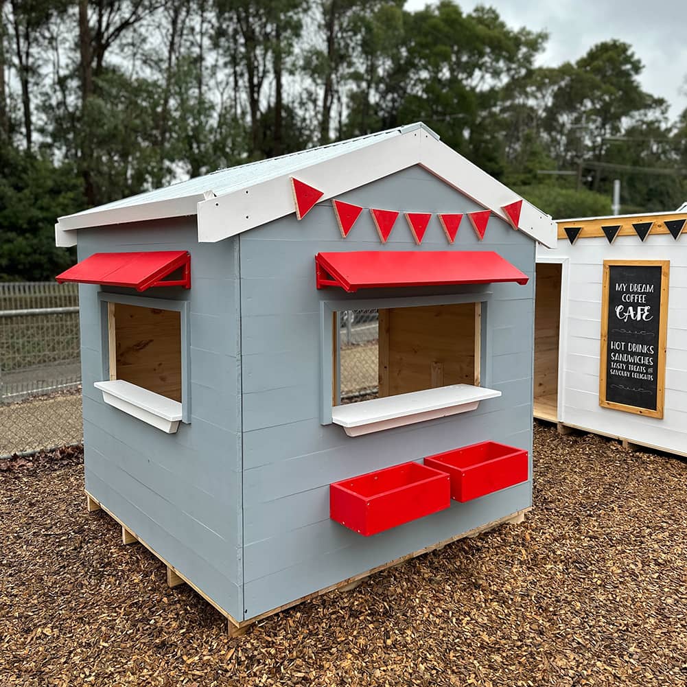 A grey  and white painted wooden vet cubby house as part of a school cubby village