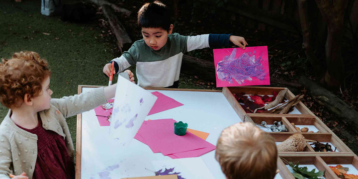 An Art and craft table with paint brushes and papers