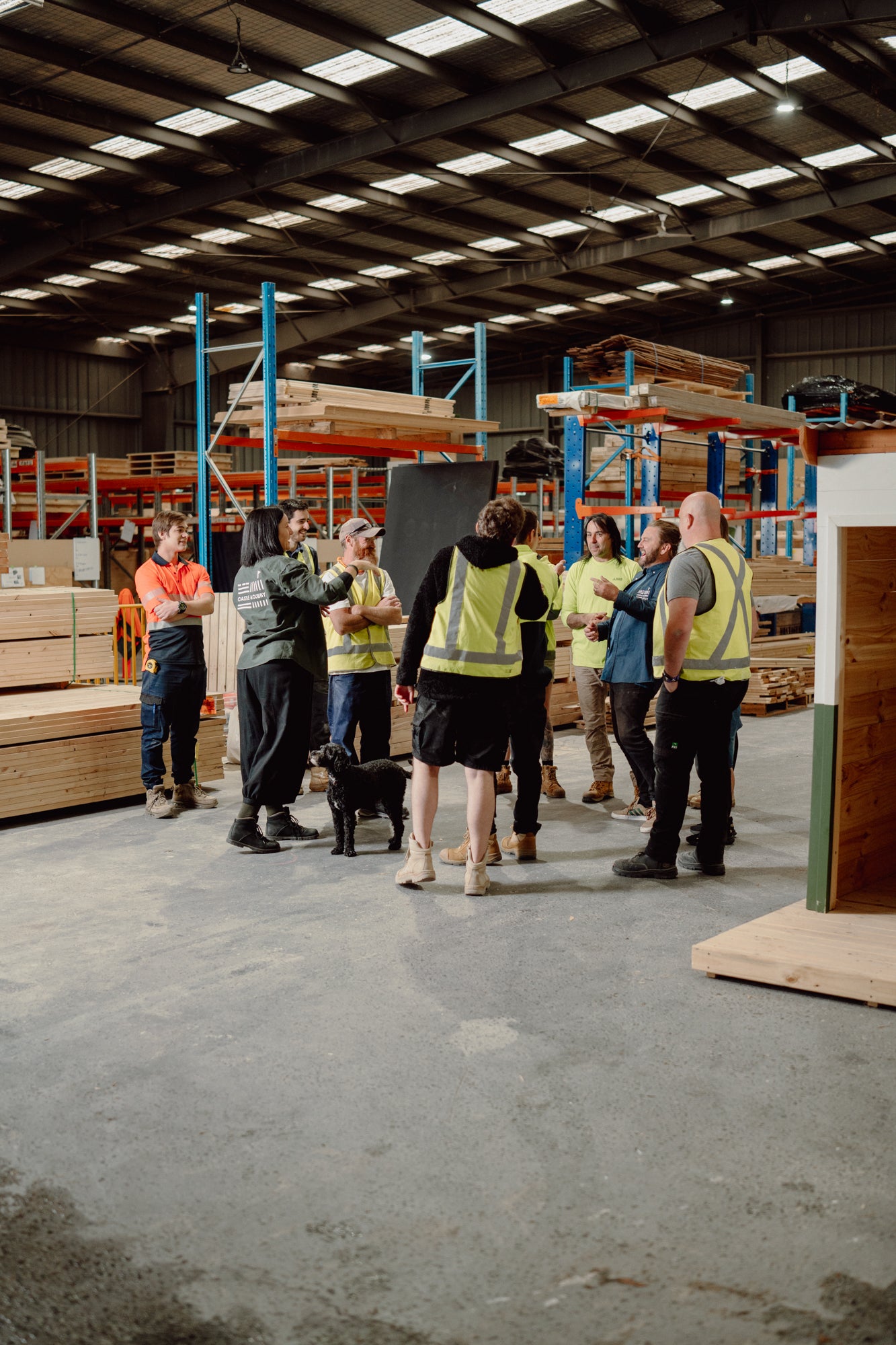 The Castle and Cubby workshop staff standing in the workshop having a team meeting. 