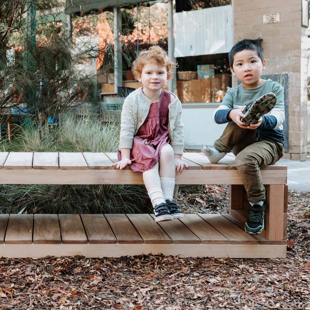 kids sitting on a wooden bench