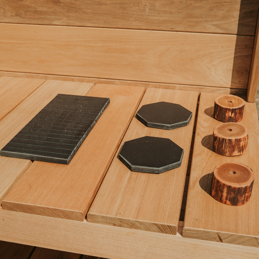 Image of the outdoor mud kitchen stovetop components including wooden oven knobs